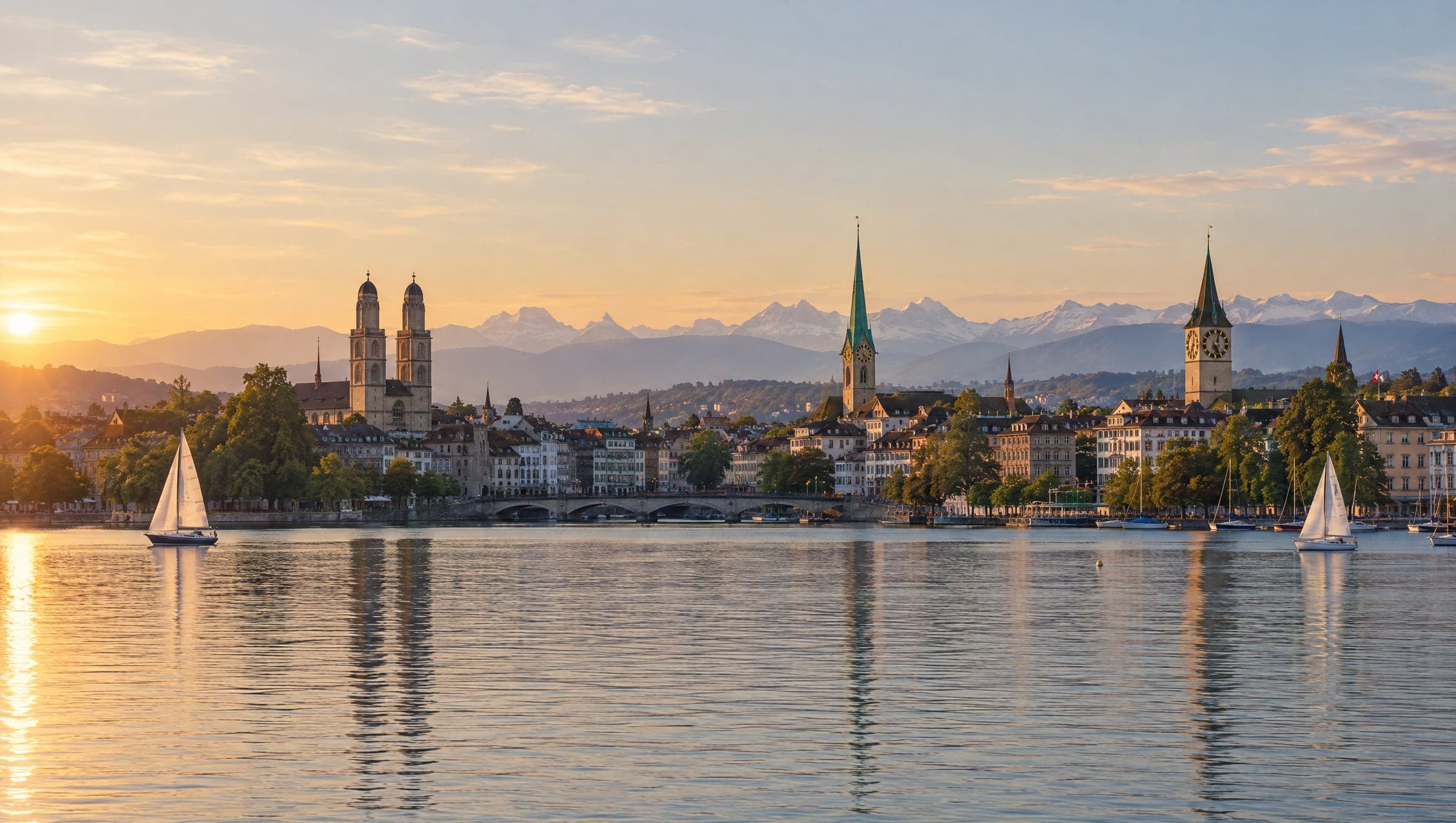 Lake Zurich at sunset, the old town with its church towers along the shore and the Alps behind